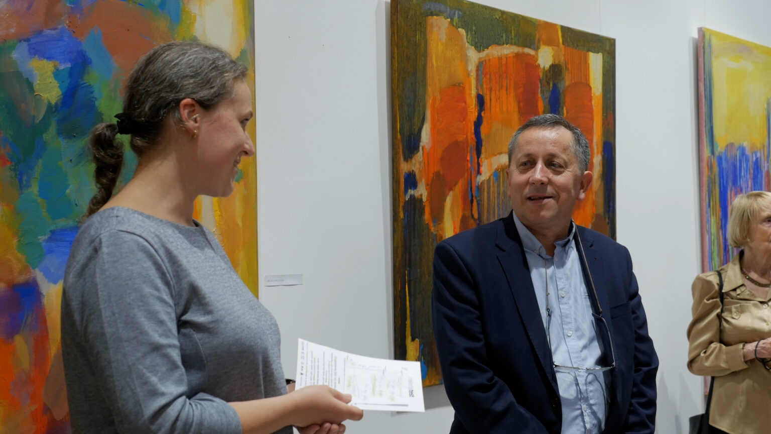 Sylwester Piędziejewski na tle swoich obrazów wernisażu