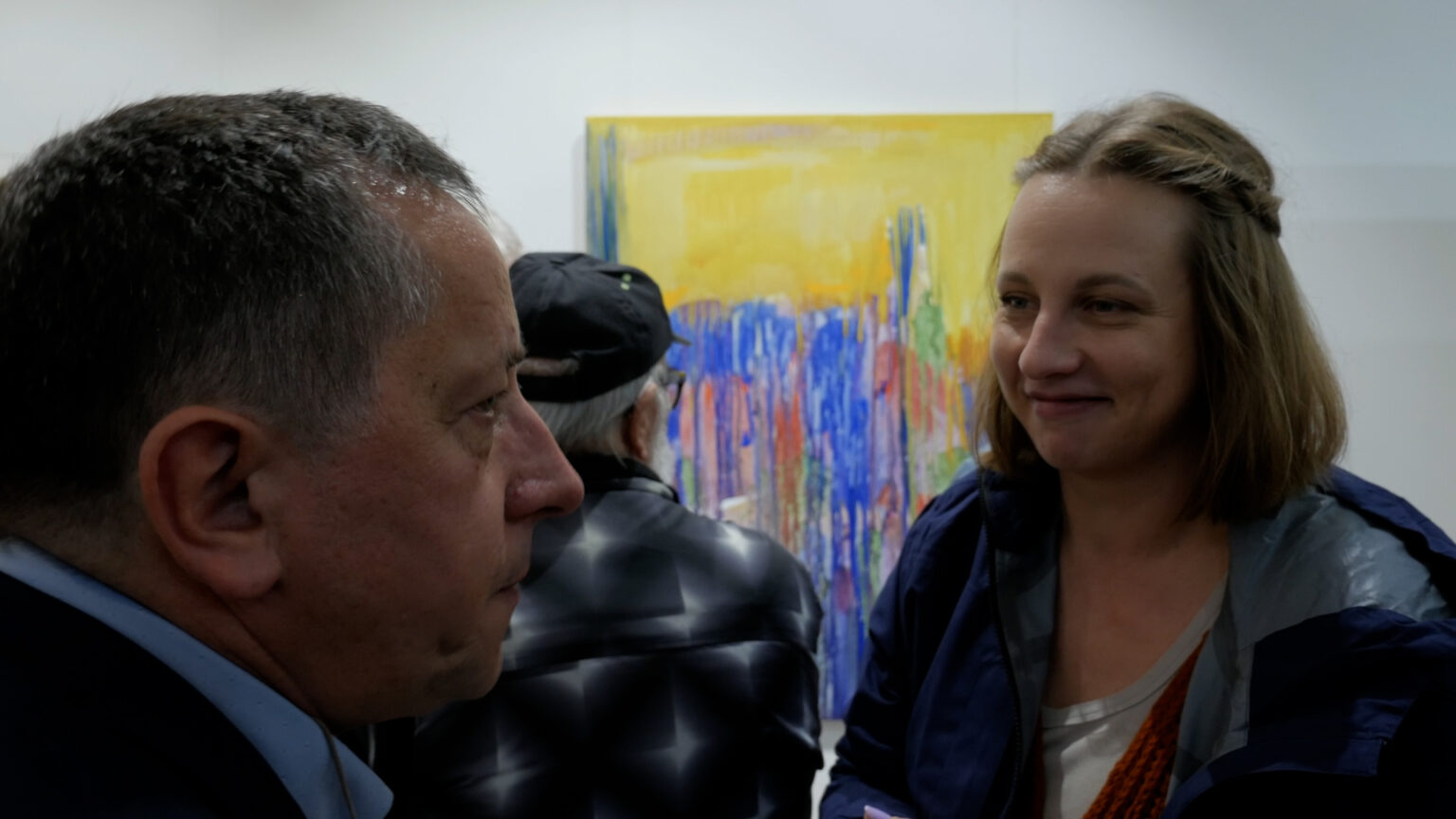 Sylwester Piędziejewski na tle swoich obrazów wernisażu