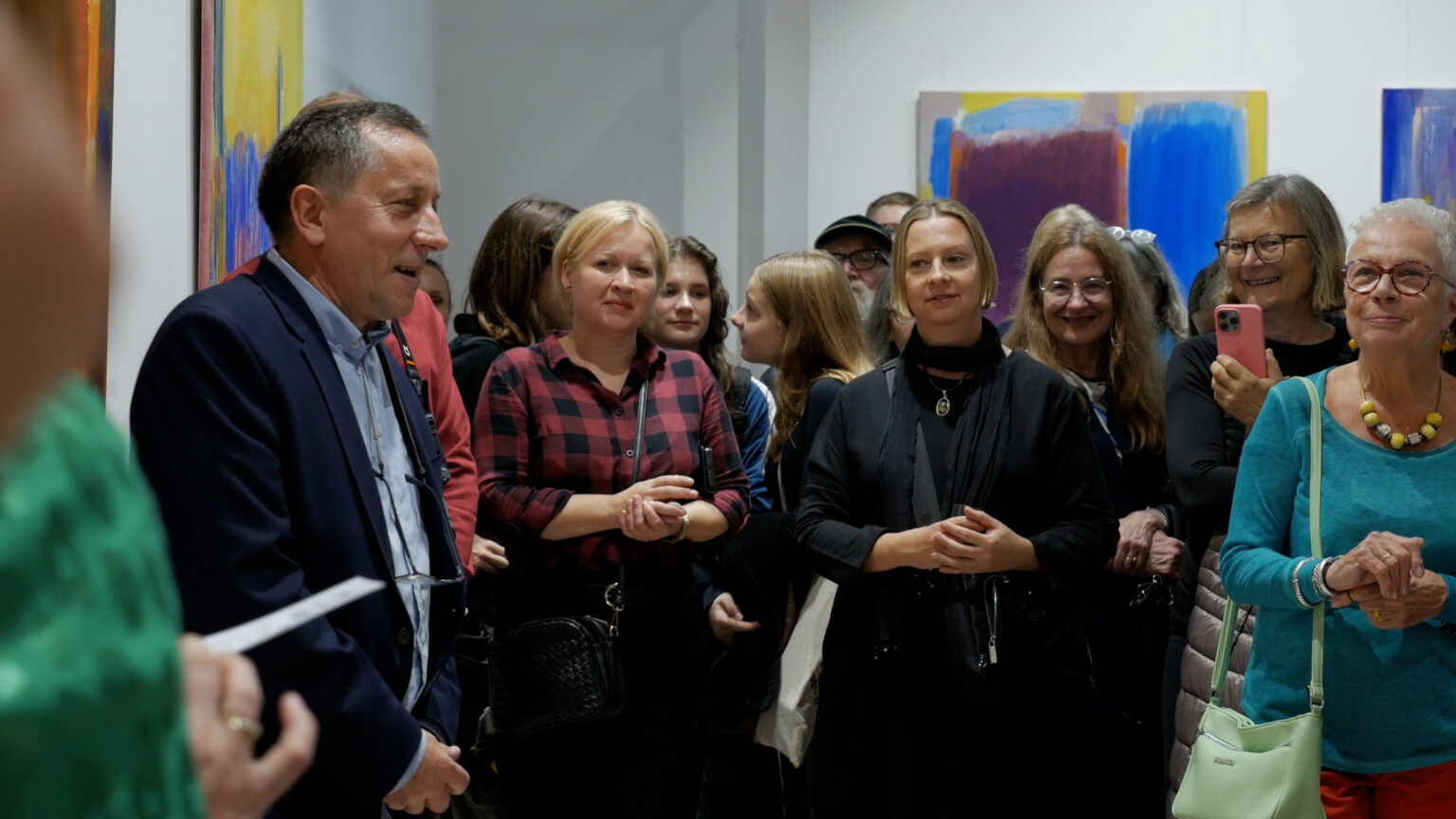 Sylwester Piędziejewski na tle swoich obrazów wernisażu