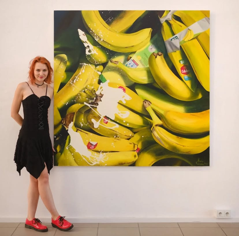 Klara Kaczyńska na tle Swojej pracy przedstawiającej przeskalowane banany