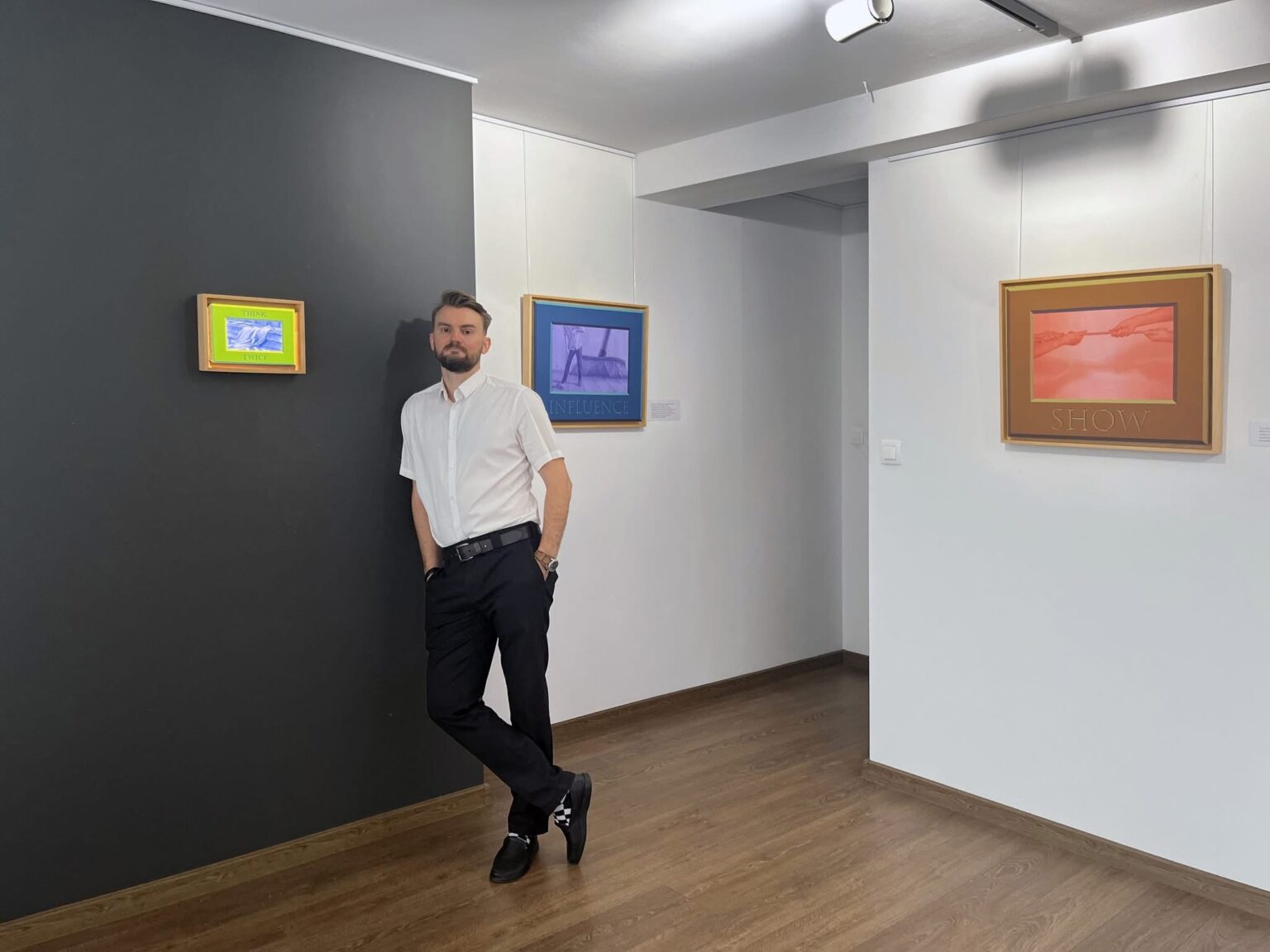 Arkadiusz Karapuda na tle swoich prac na wystawie